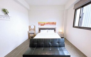 A bedroom with a bed, a bedside table, a lamp, a window, and a painting on the wall. - Yuanshan Dahu Homestay (Yuanshan)