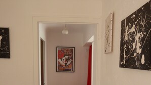 A compact living space with a red leather sofa, a washing machine, and a small kitchenette. - House with garden, close to the beach, the port and the river shuttle (boucau)