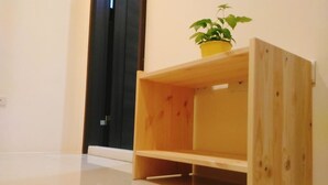 A wooden shelf with a potted plant in a yellow pot. - He-Tian - Cafe & Bar (Puli)