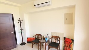 A room with a wooden door, a coat rack, a table with chairs, and a painting on the wall. - He-Tian - Cafe & Bar (Puli)