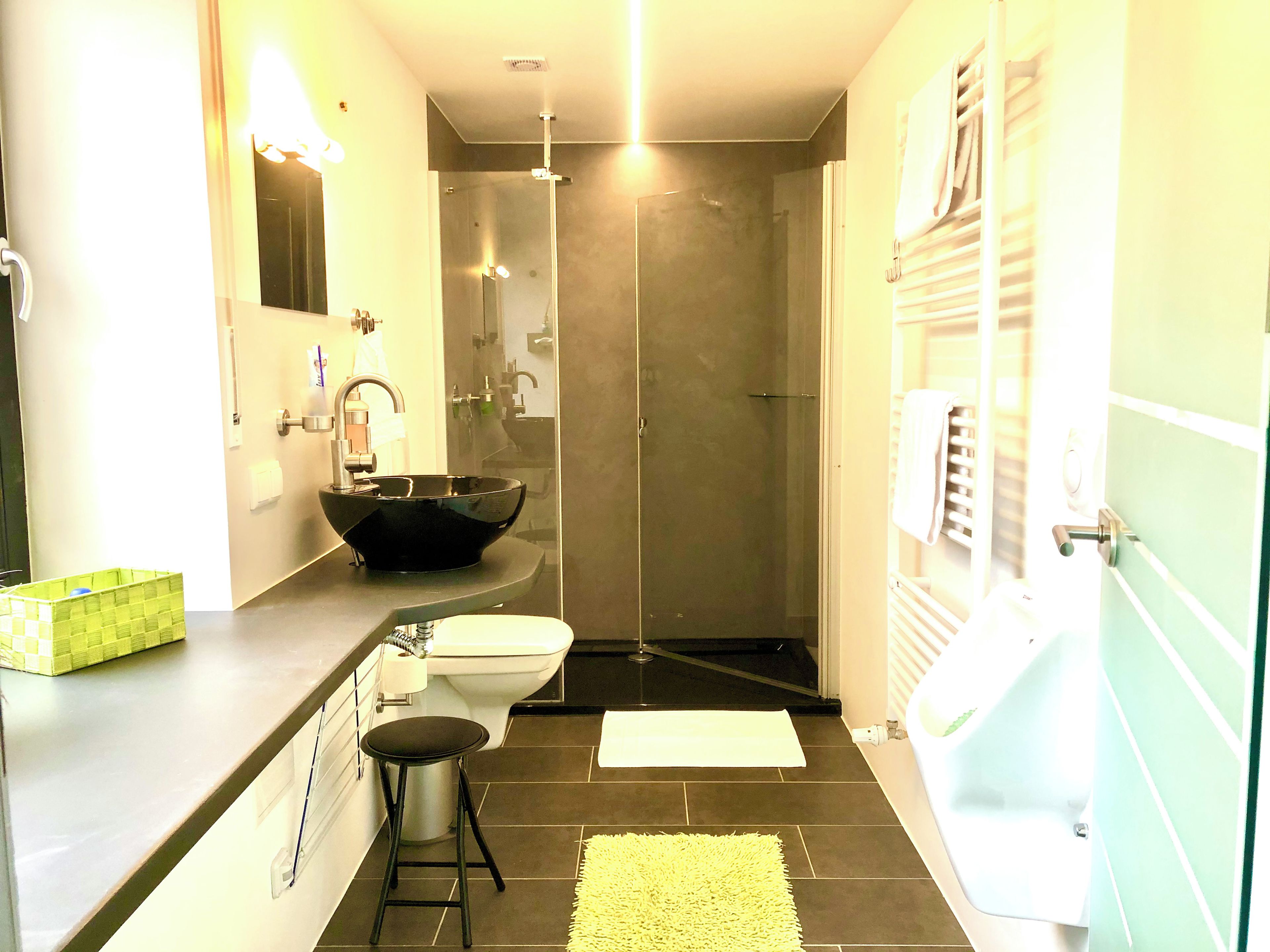 Ein Badezimmer mit einem schwarzen Waschbecken, einer Toilette, einer Dusche und einer Badewanne.