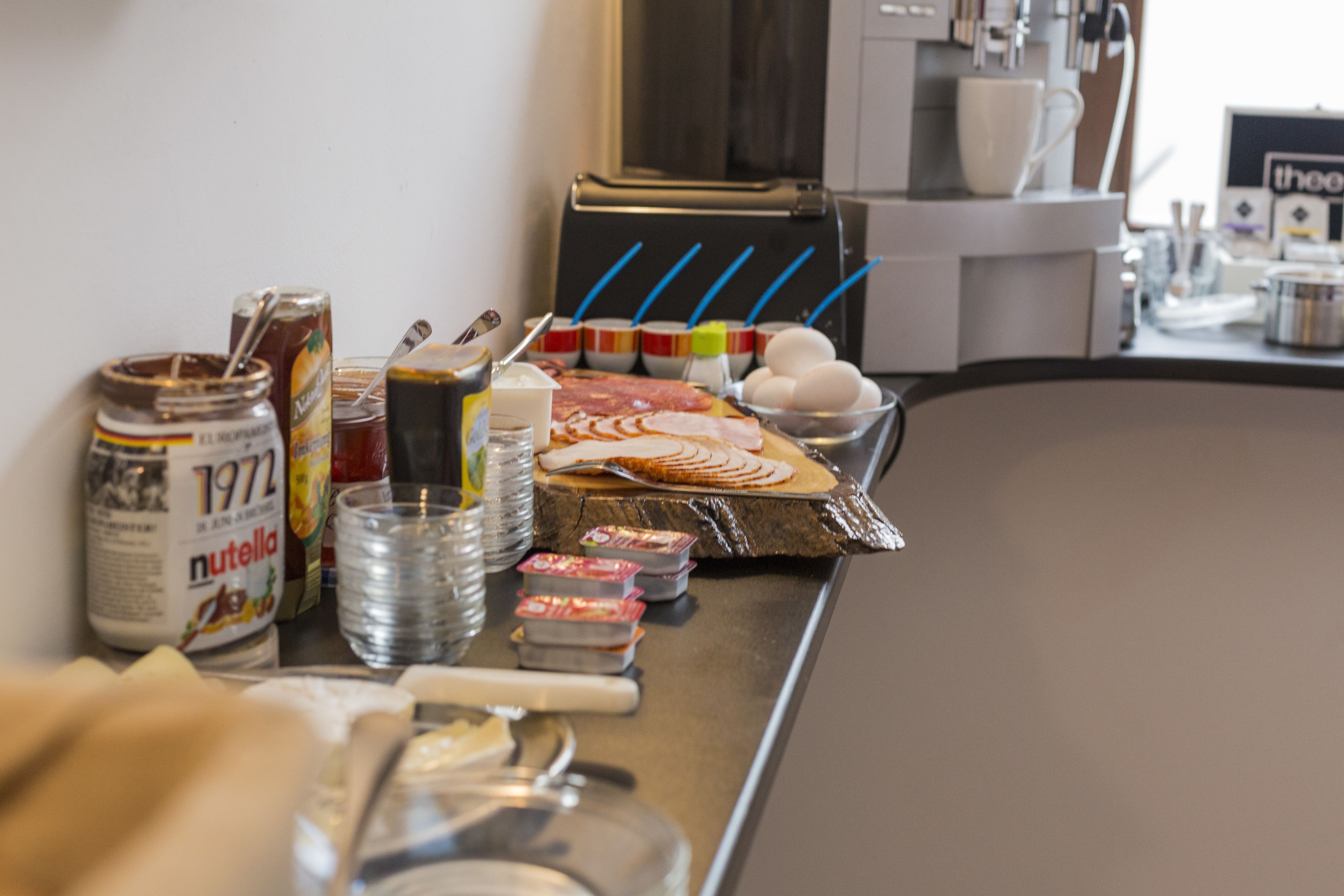Un bufé de desayuno con diversas opciones de comida, salsas y utensilios.