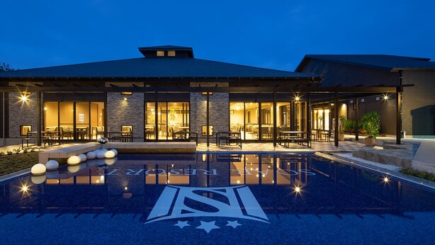 Une maison moderne dotée d’une piscine, d’un espace extérieur aménagé et d’un intérieur bien éclairé.