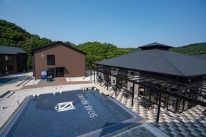 A pool area with a checkered floor and a building labeled "E" in the background. - Soar Resort (Tsushima)