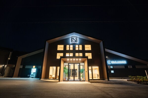 A hotel entrance with a modern design, featuring a prominent logo above the doors and a sign indicating the name 'SOAR RESORT'. - Soar Resort (Tsushima)
