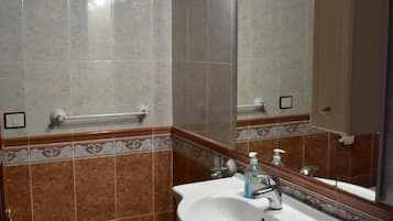 A bathroom with a white sink, a mirror, and a towel rack.