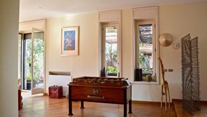 Una habitación con mesa de fútbol de madera, una escultura de jirafa y un reloj de pared.
