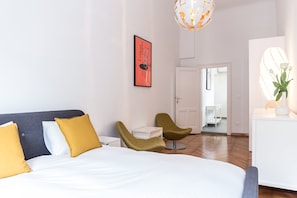 Ein modernes Hotelzimmer mit Bett, Schreibtisch, Stuhl und einer Pendelleuchte.