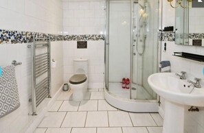 A modern bathroom with a toilet, shower, and sink. - Charming 5-bed House in Boston Lincolnshire (Boston)