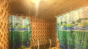 Ein Badezimmer mit karierten Fliesenwänden, einem Duschvorhang mit Meeresmotiv und einem gefliesten Boden.
