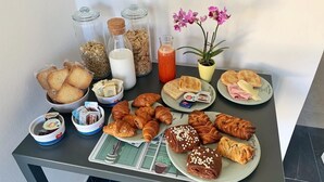 A breakfast buffet with various pastries, bread, and condiments on a table. - B&B Mikeme (Carrara)