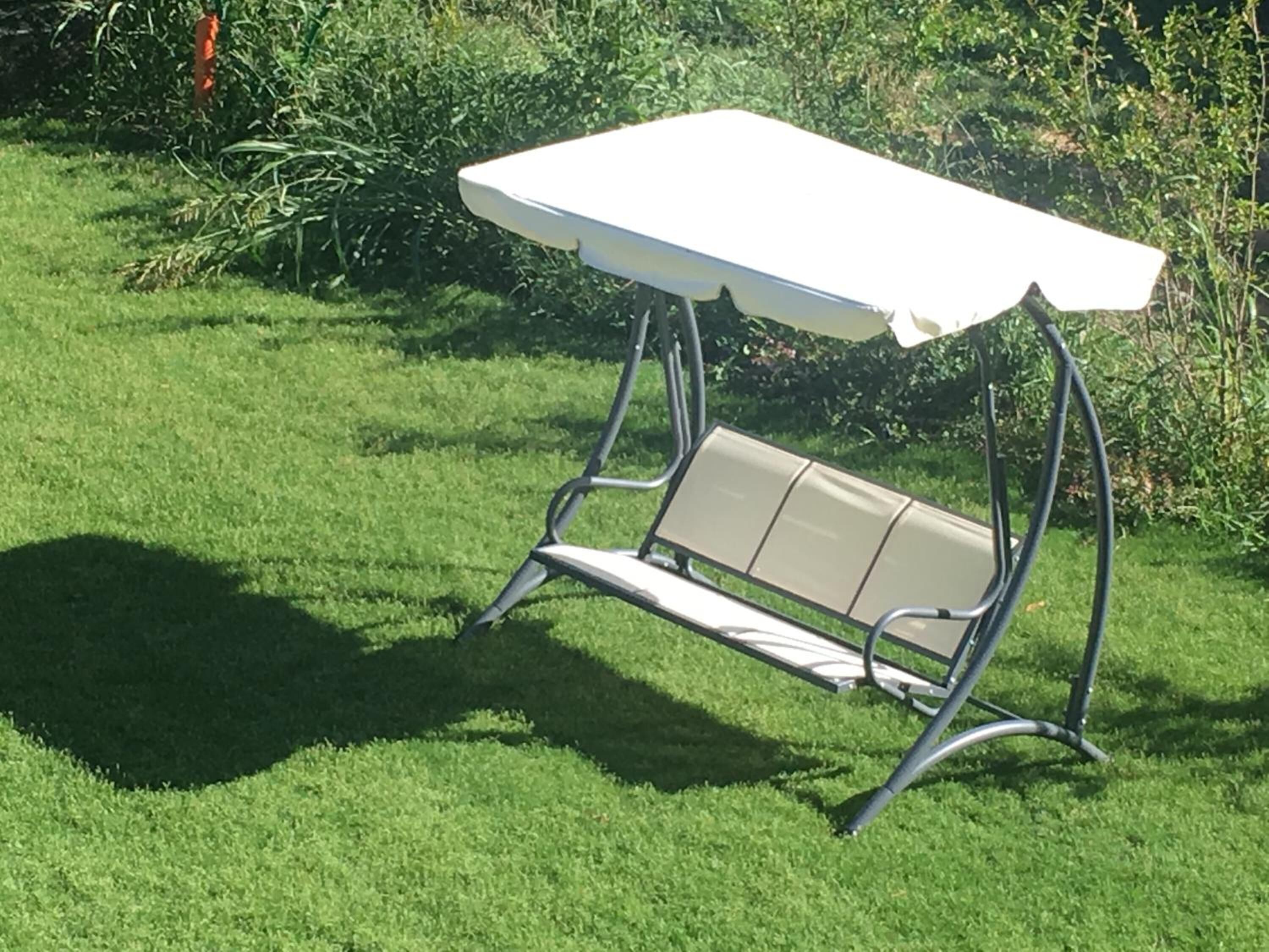 Una mesa blanca al aire libre con un banco.