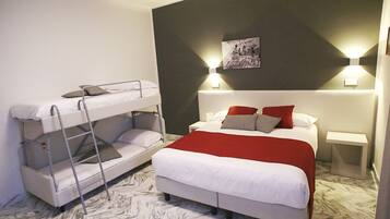 Una stanza con un letto a castello, un letto singolo, una testiera con copriletto rosso e bianco e due lampade da comodino.