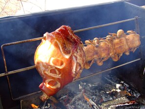 A large whole pig roasting over an open fire. - Chalupa Podlesí (Korenov)