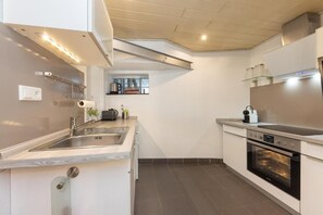 A modern kitchen with a built-in oven, stainless steel sink, and a window above the countertop. - Hostel FerienNest Haus Braunfels (Bad Ems)