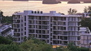 A multi-story hotel with a modern architectural design, featuring balconies and large windows.
