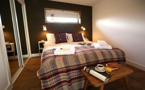 Relax in a spacious room with a large bed, nightstand, and window offering a view of the outside.