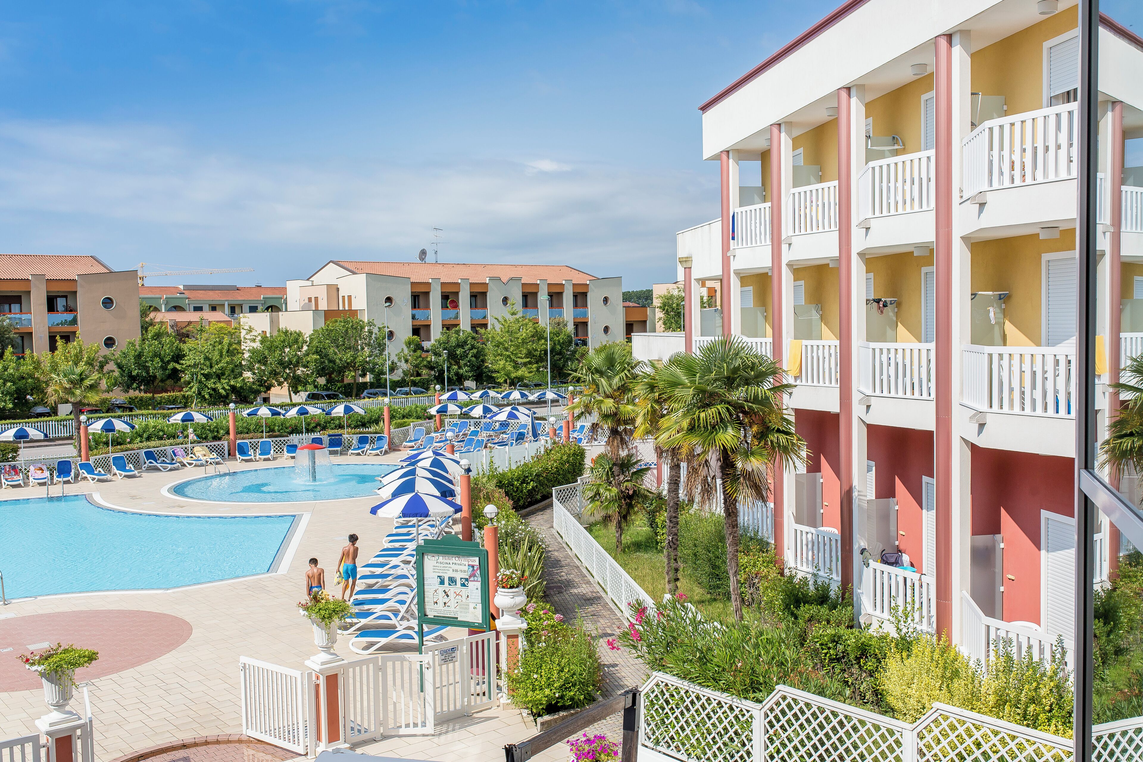 Un resort con piscina, sombrillas y un edificio con balcones.