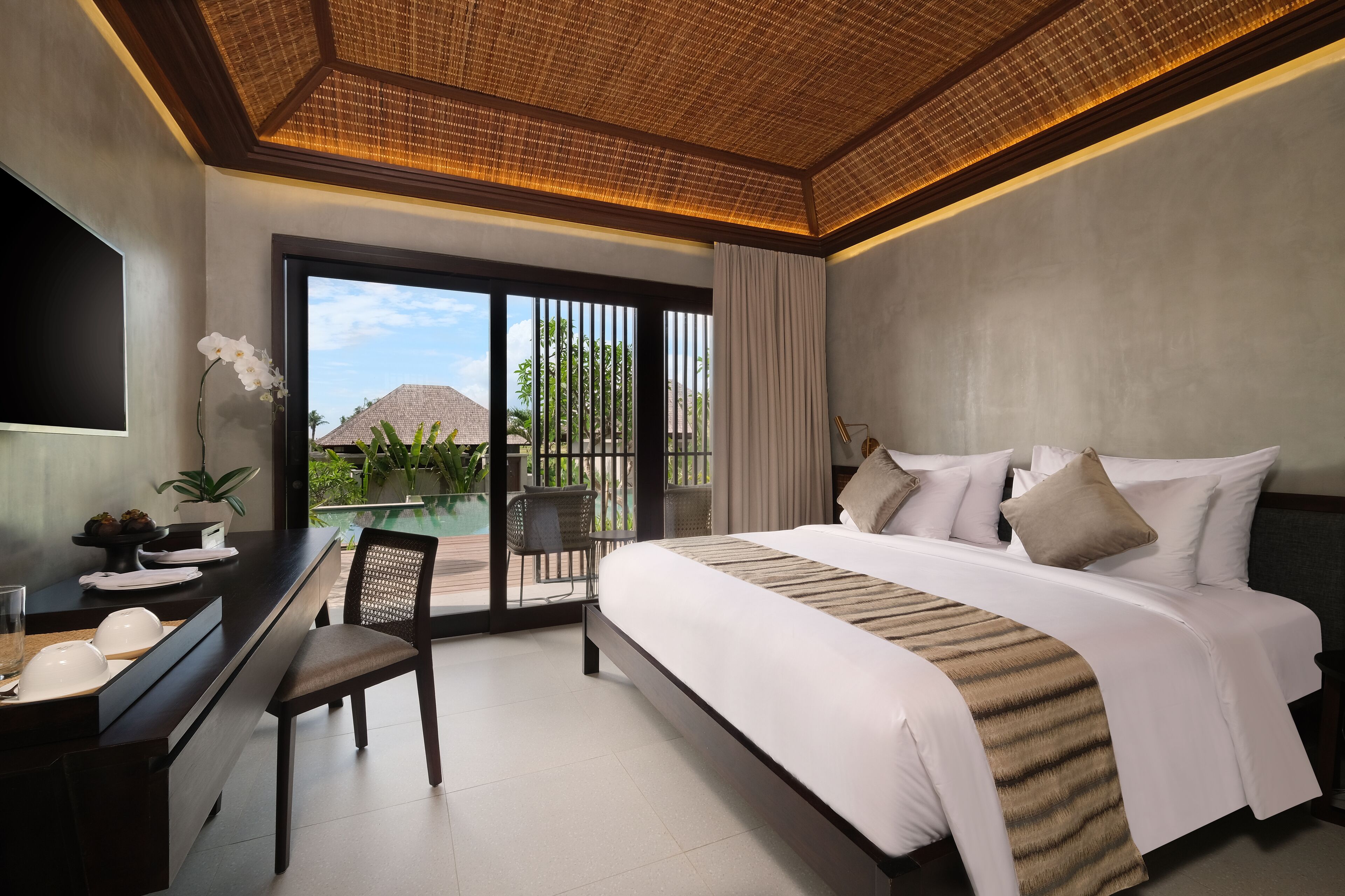 Habitación de hotel moderna con una cama grande, un escritorio y vistas al exterior.
