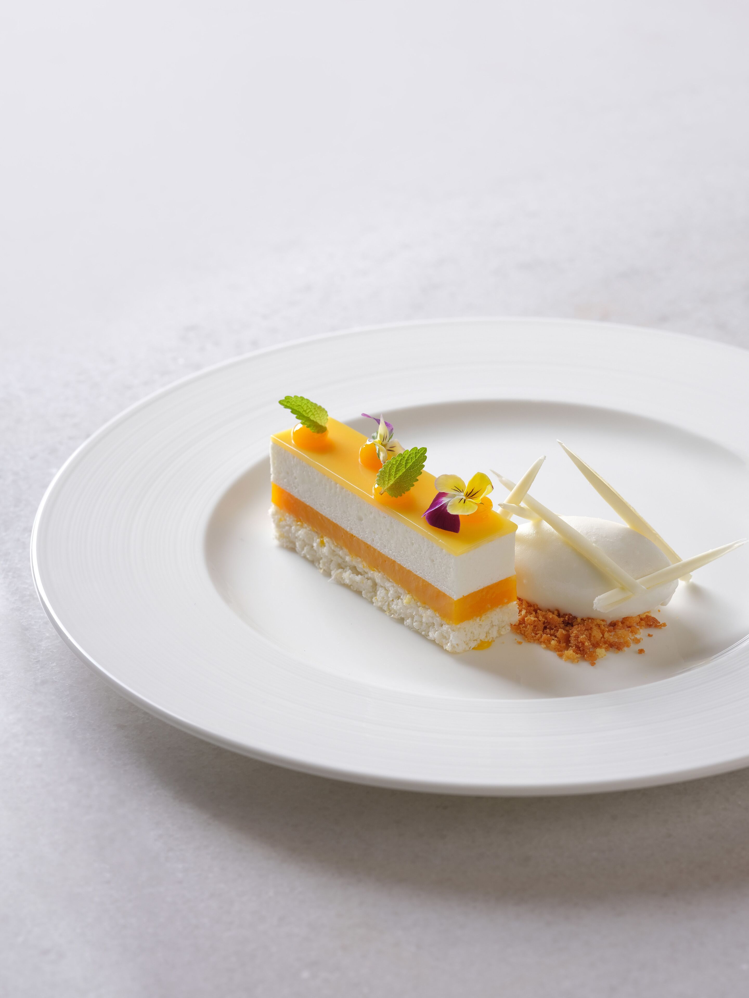 A slice of layered dessert on a white plate.