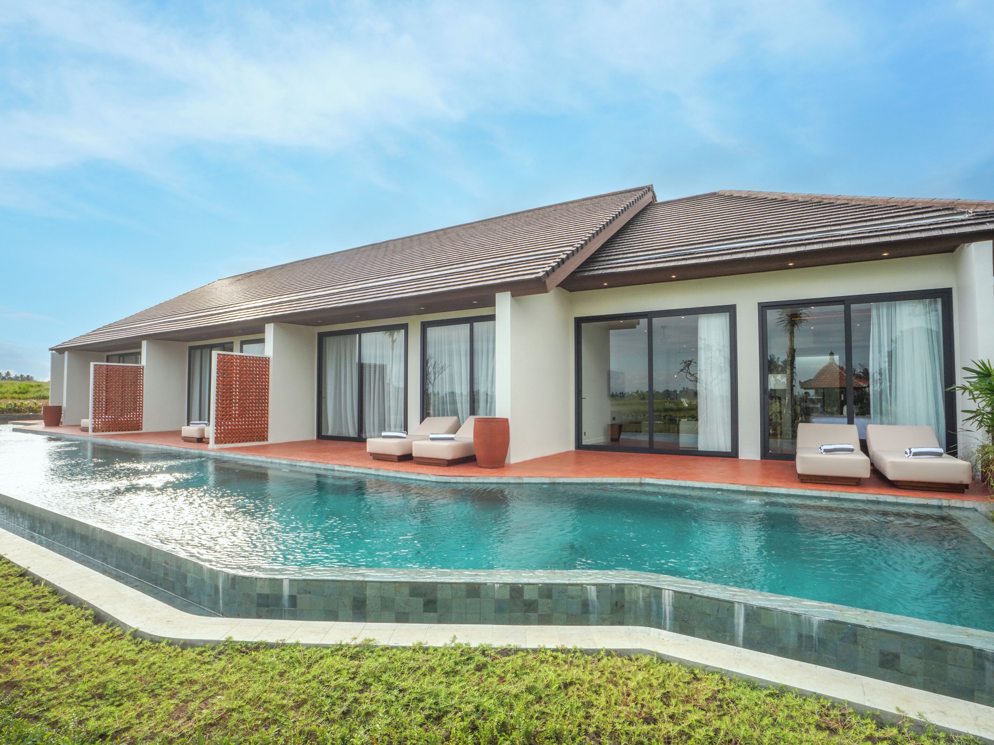 A modern house with a swimming pool, large windows, and outdoor seating.