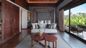 A modern living room with a large sofa, a coffee table, and a view of lush greenery outside. - The Garcia Ubud Hotel & Resort (Ubud)