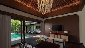 A modern living room with a dining area, a large TV, and a pool view. - The Garcia Ubud Hotel & Resort (Ubud)