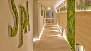A corridor with a wooden floor, green wall decor, and a sign reading "SPA". - Parkhotel Bad Griesbach (Bad Griesbach im Rottal)