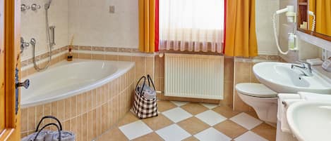 Un baño con bañera, inodoro y lavamanos.