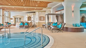 A pool area with lounge chairs and a hot tub. - Parkhotel Bad Griesbach (Bad Griesbach im Rottal)
