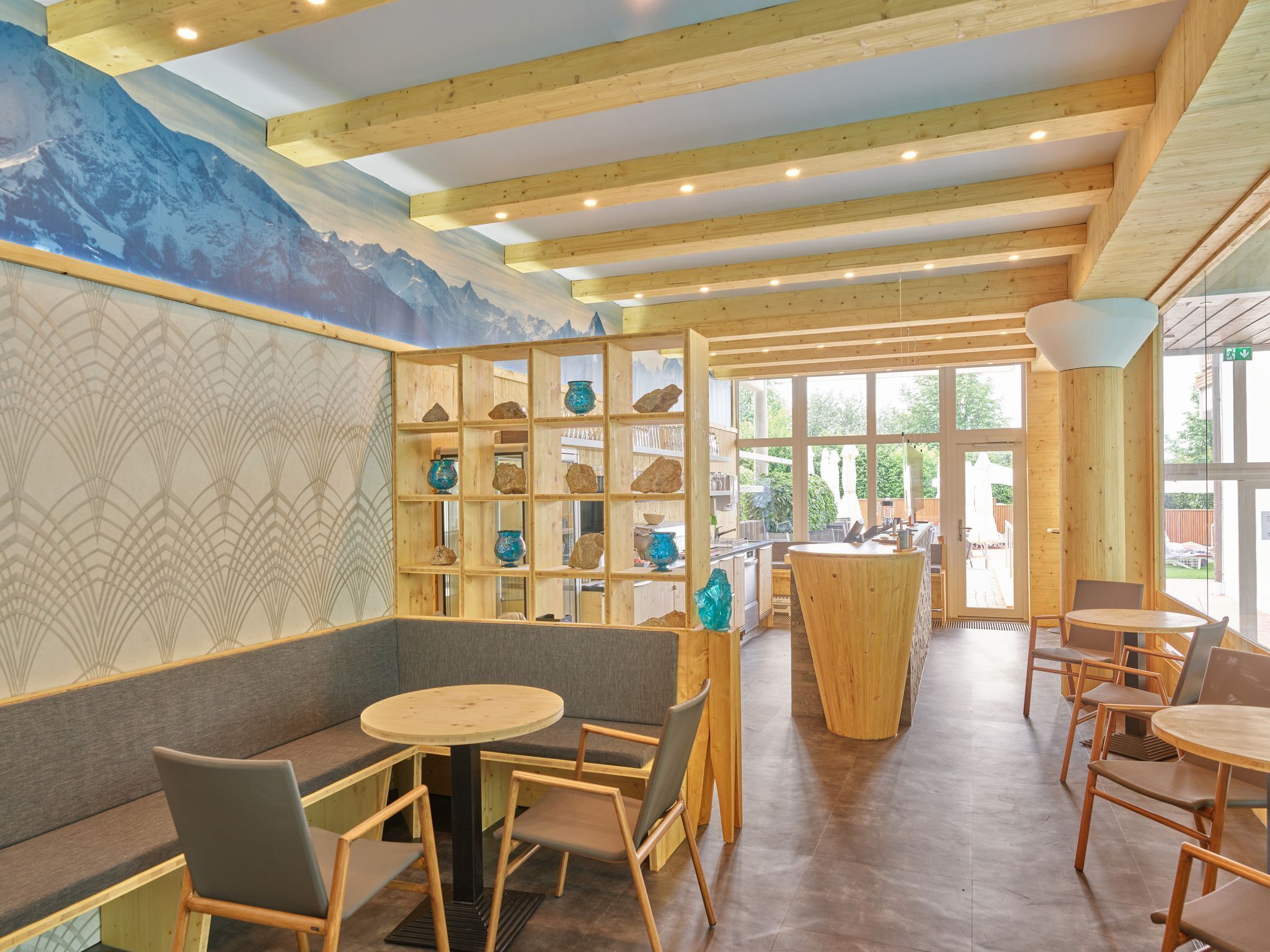 A restaurant with wooden beams, a mural, and a seating area with tables and chairs.