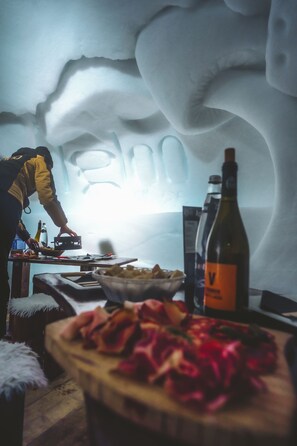 A person preparing food in a room with a unique ice wall design.