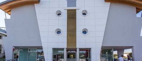 A modern building with a unique architectural design, featuring a central vertical element and circular windows.