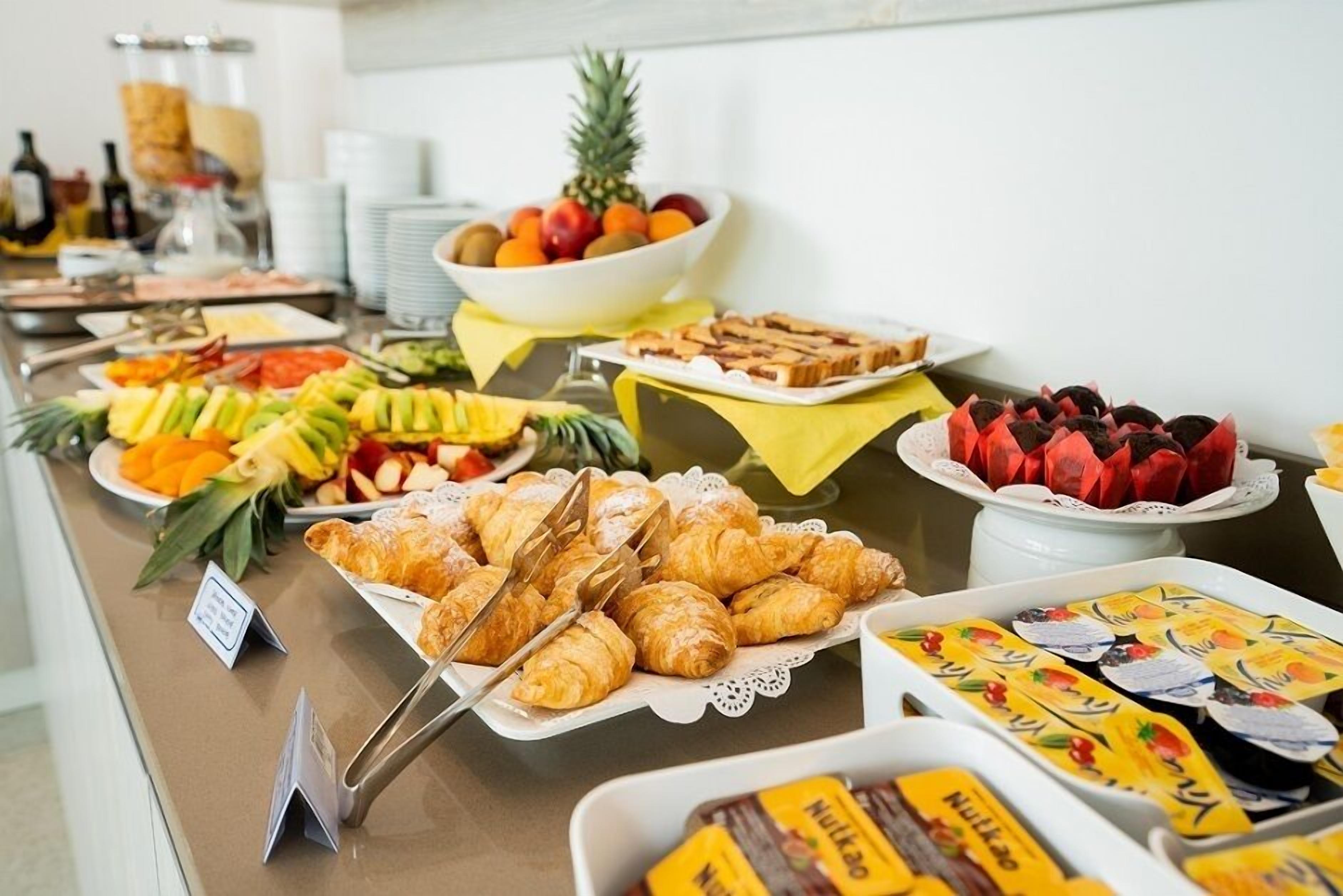 Un bufet amb diversos aliments, com ara fruita, pastissos i aperitius envasellats.