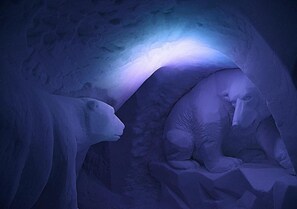 An ice sculpture of a polar bear and a cub in an ice cave.