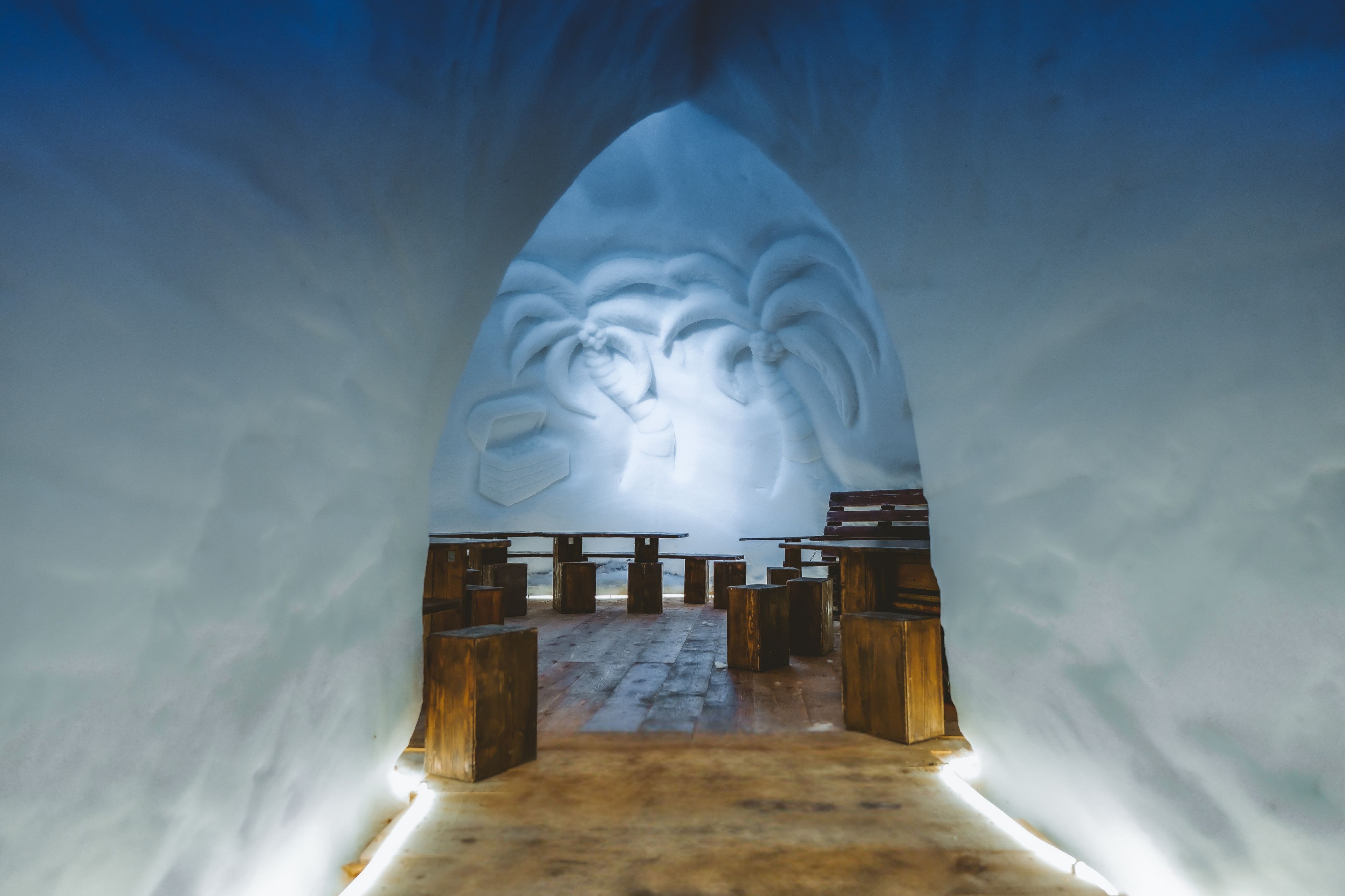 An igloo with benches and a carved entrance.