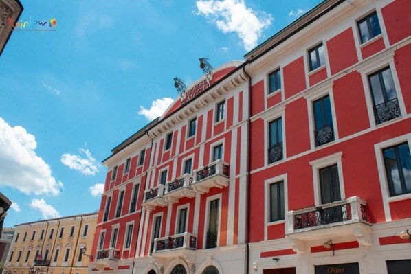Un edificio rojo y blanco con varios balcones y ventanas.