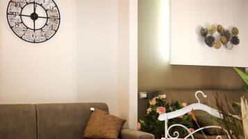 Une pièce avec un canapé marron, une horloge murale et un élément décoratif en métal.