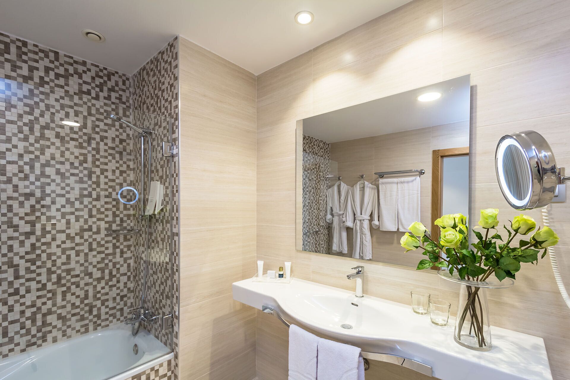 A modern bathroom with a shower, a sink, and a mirror.