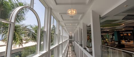 A modern interior with a glass balustrade, a central walkway, and a reception area.