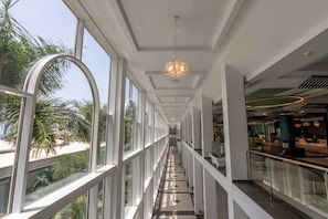A modern interior with a glass balustrade, a central walkway, and a reception area.