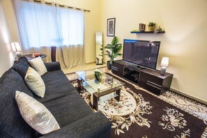 Relax in this stylish living room with a sofa, coffee table, and flat-screen TV.