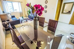 Relax in this stylish living room with a glass-top dining table, comfortable leather chairs, and a large mirror.