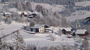Eine verschneite Berglandschaft mit mehreren Holzhäusern und Hütten.