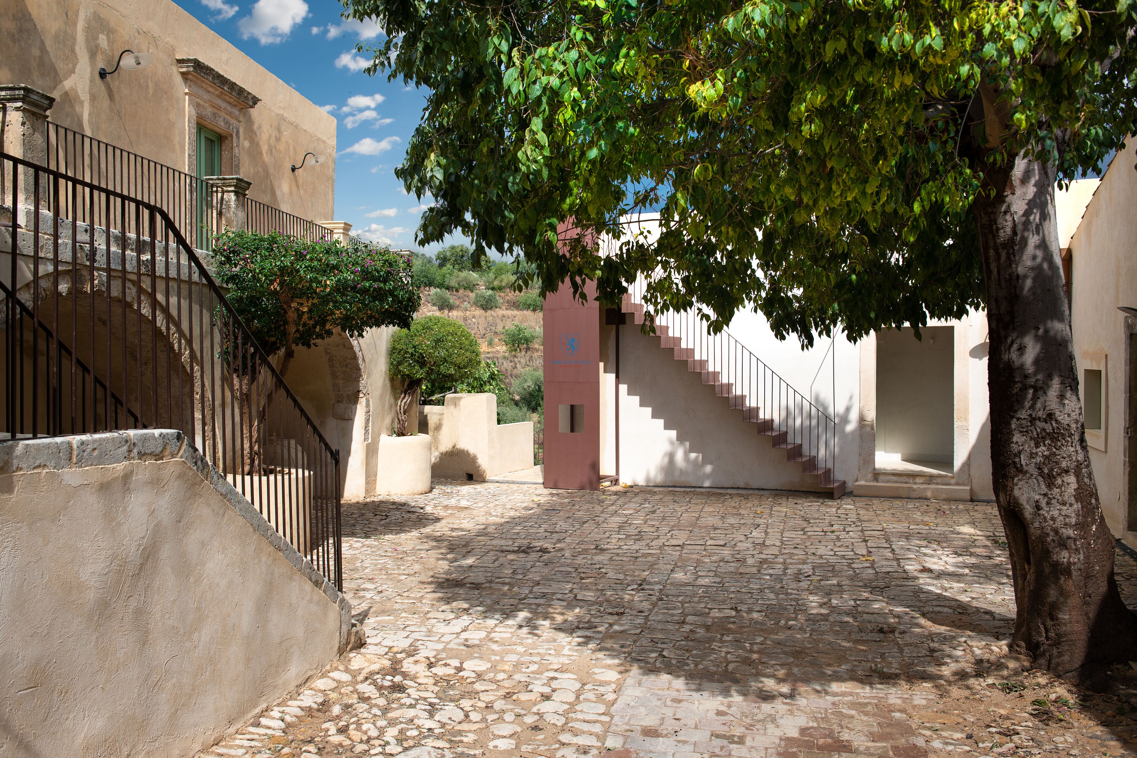 A cobblestone street with a staircase leading to a building entrance.