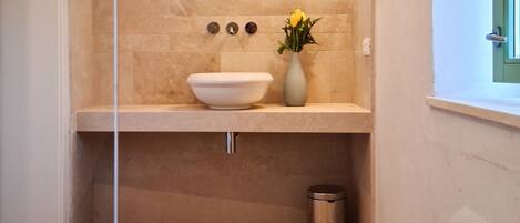 A compact bathroom with a white toilet, a white sink, and a mirror above the sink.