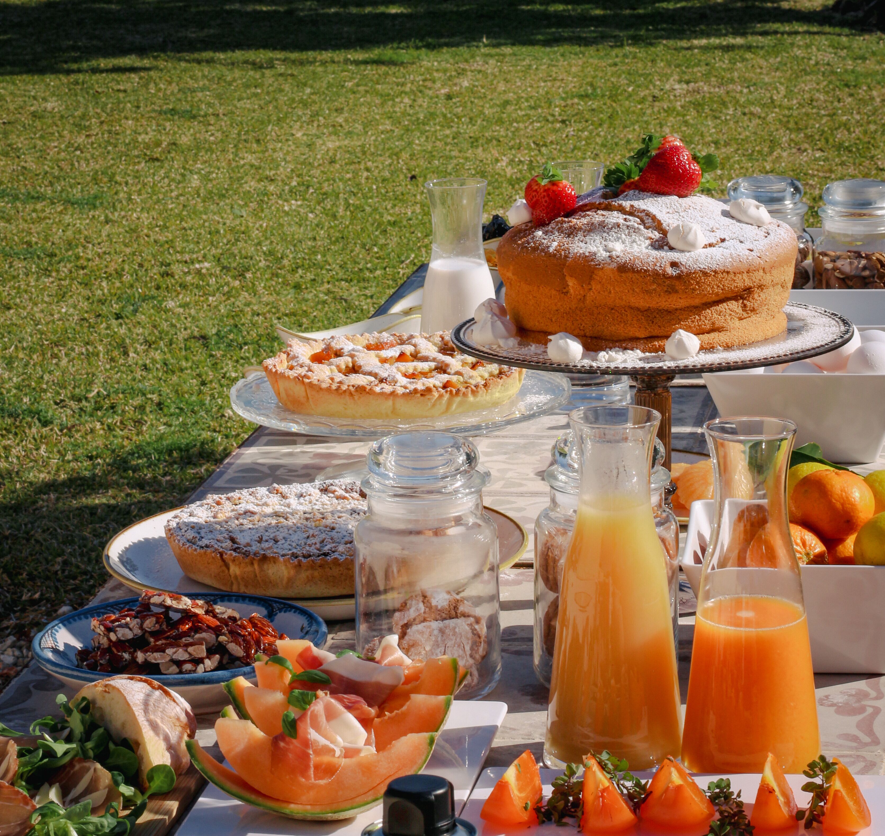 Una mesa al aire libre con alimentos y bebidas para un picnic.