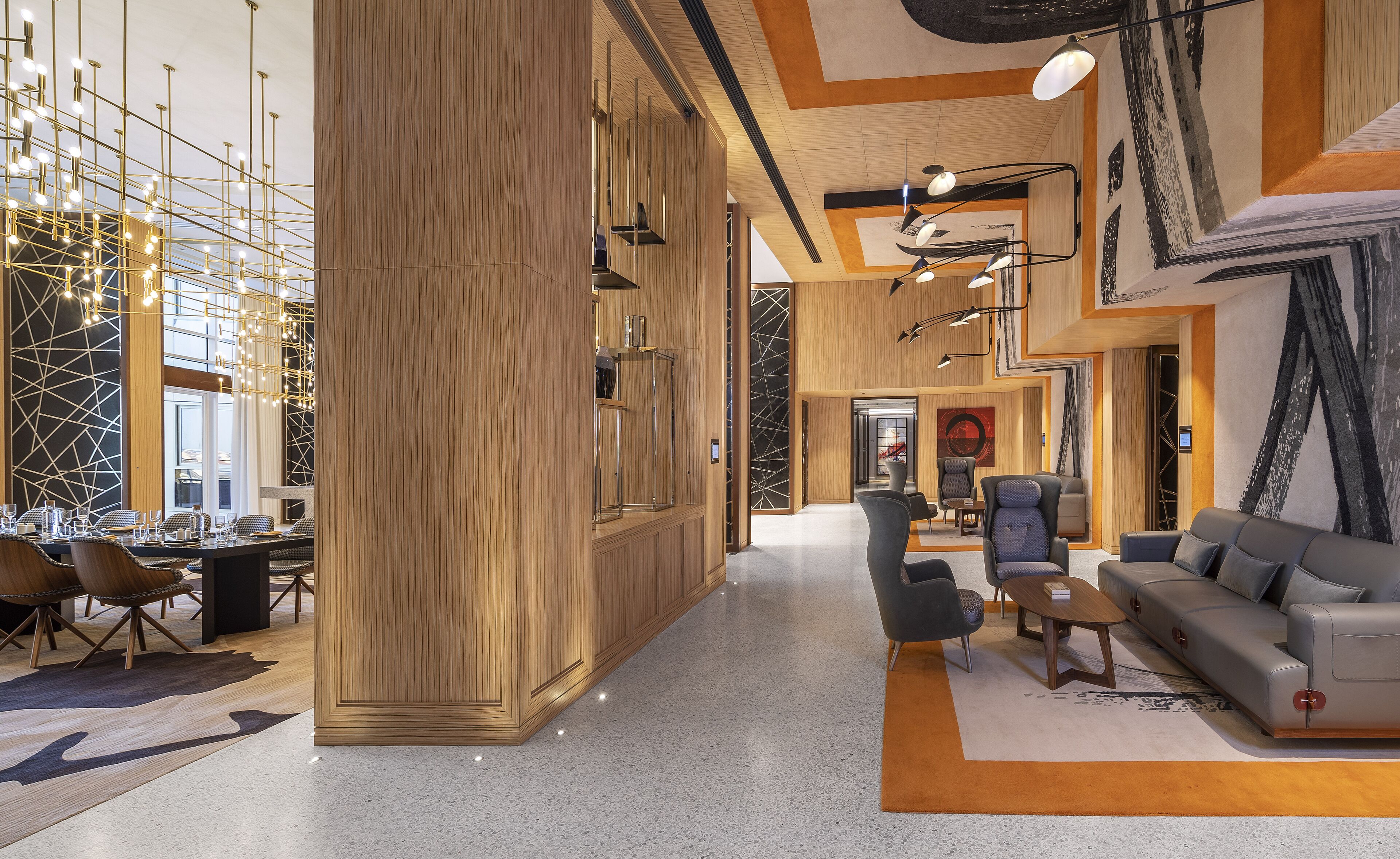 A spacious lobby with a high ceiling, modern lighting fixtures, and a mix of seating areas including sofas and chairs.