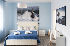 A bedroom with a bed, a bedside table, a desk, and a chair.