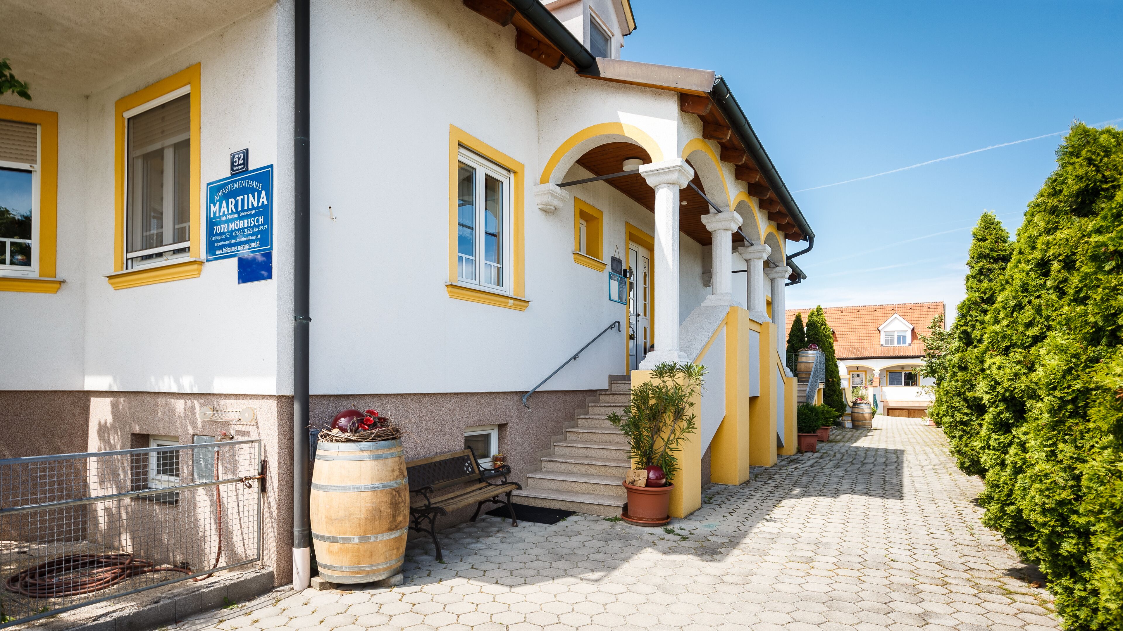 Um edifício com uma placa indicando 'Appartementhaus MARTINA' e uma escadaria que leva à entrada.